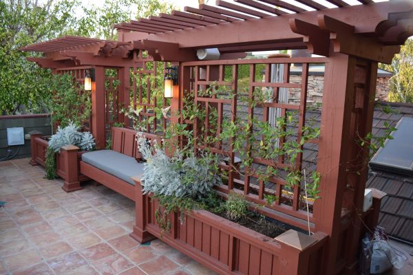 Completed trellis with planter boxes, bench seating, and lighting