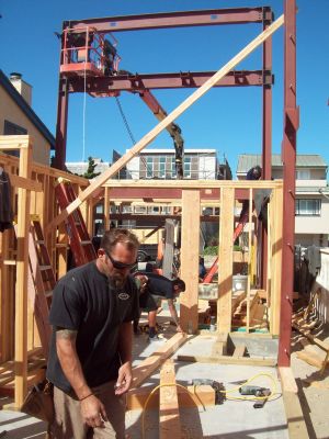 Carpenters framing first floor adjacent to steel moment frame
